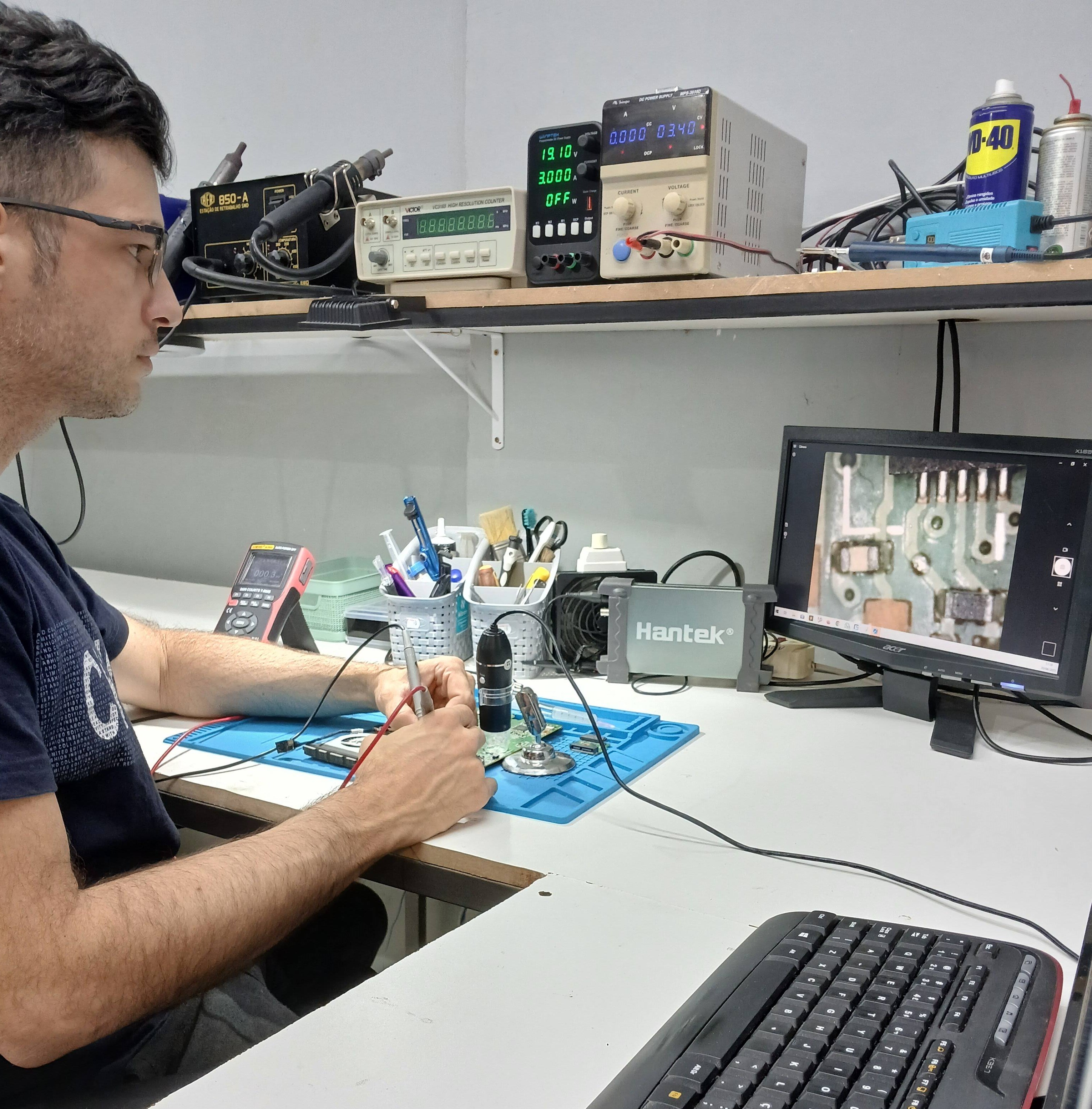 Técnico Evaldo trabalhando em laboratório de reparo de notebooks